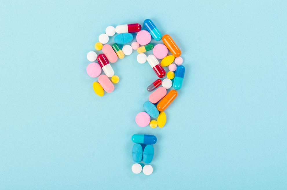 Question mark on blue background laid out of medicines