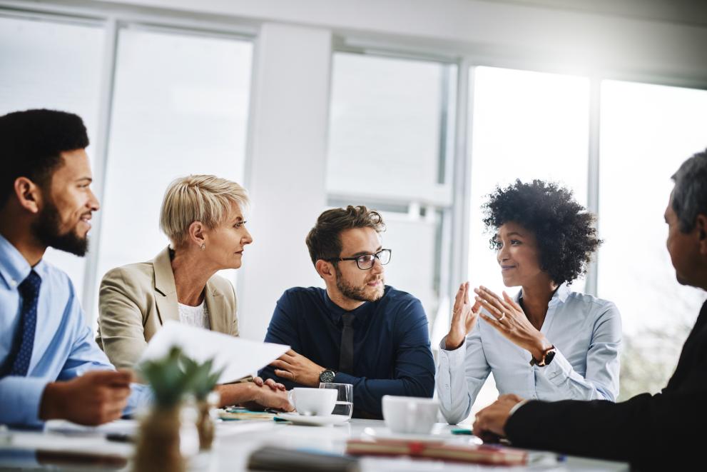 Five people having a discussion at a table